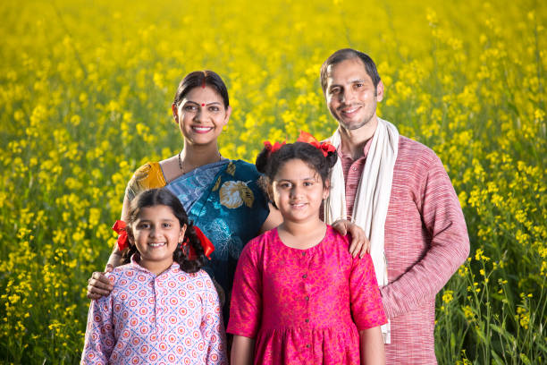 PM-KISAN Scheme: Do you know the Complete Guide to Benefits, Eligibility, Application Process & Support ? happy indian family standing in mustard agricultural field